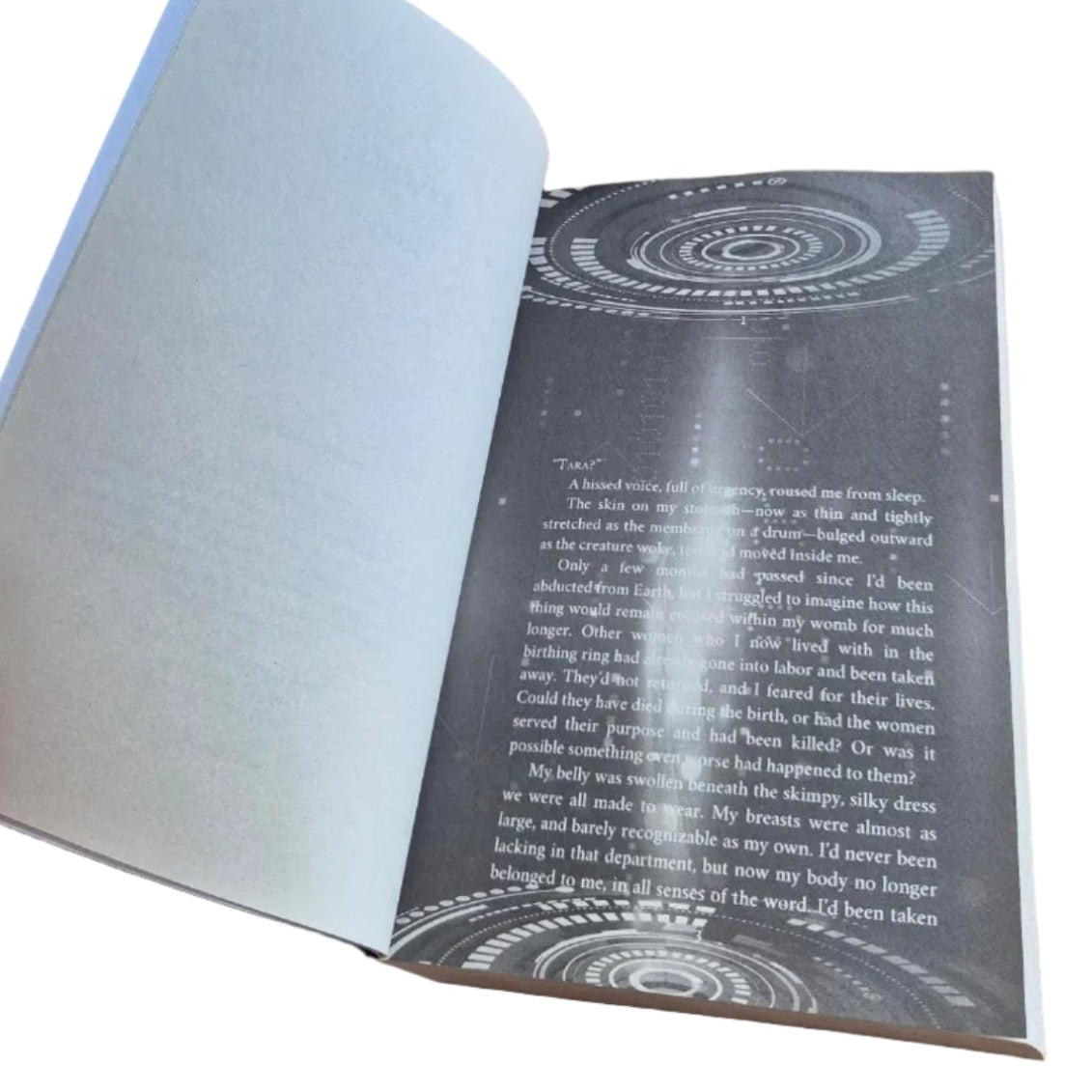 Open book with a page held up, showing white text on black background header page for The Tradrych Strain interior formatting by Marissa Farrar