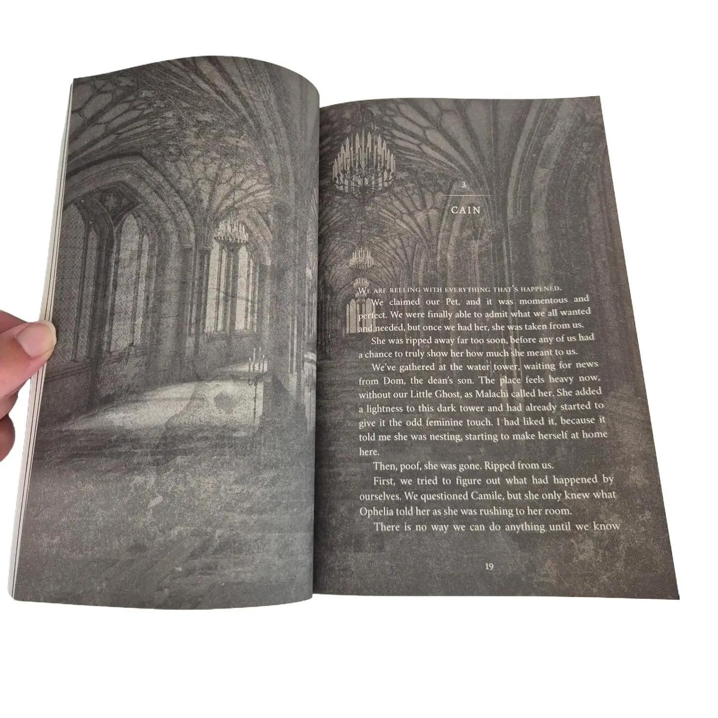 Open book showing a gothic interior and text on a white background