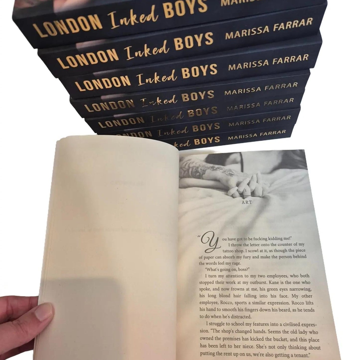 Stack of books titled 'London Inked Boys' by Marissa Farrar with an open book in front