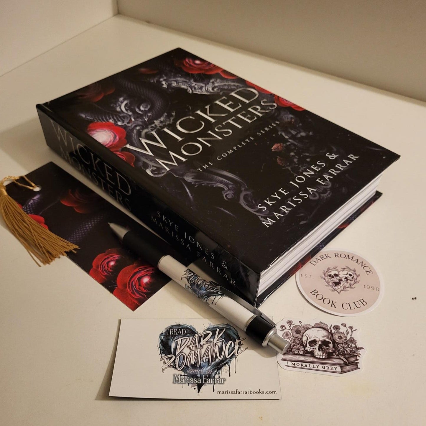 hardback of Wicked Monsters lying flat with accompanying swag