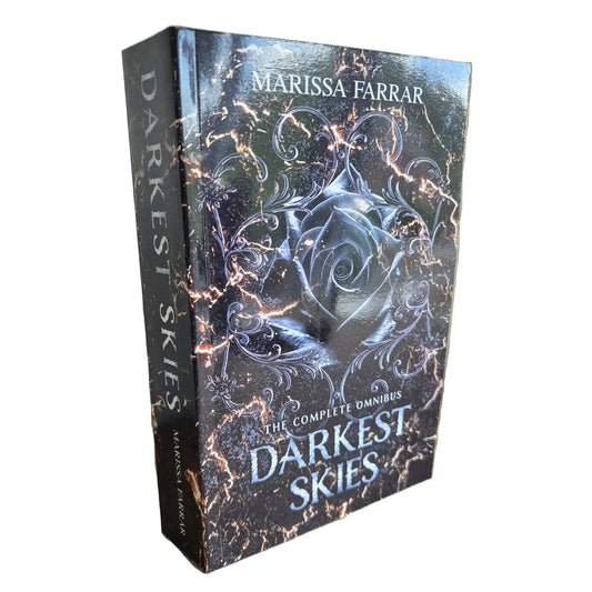 Book titled 'Darkest Skies' by Marissa Farrar on a wooden surface with a neutral background