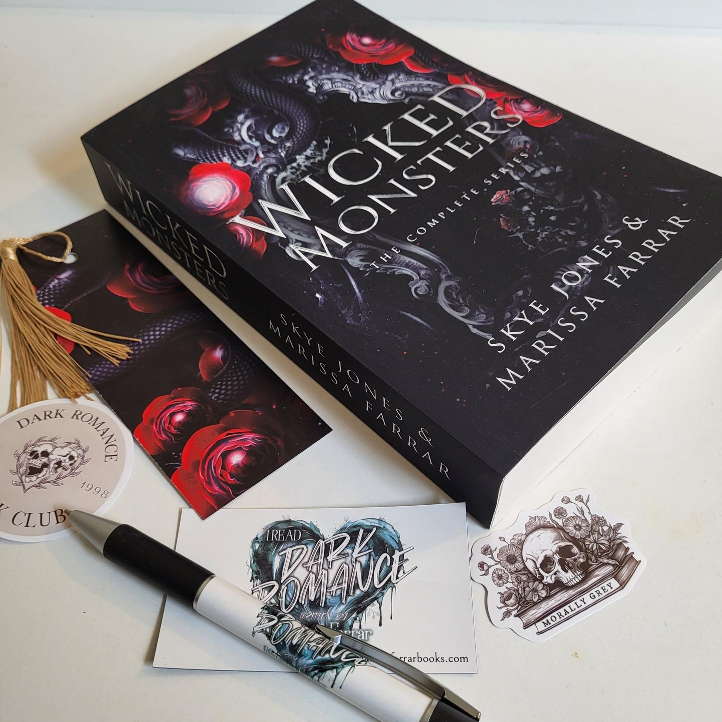 Paperback of Wicked Monsters together with branded pen, stickers, magnet and bookmark